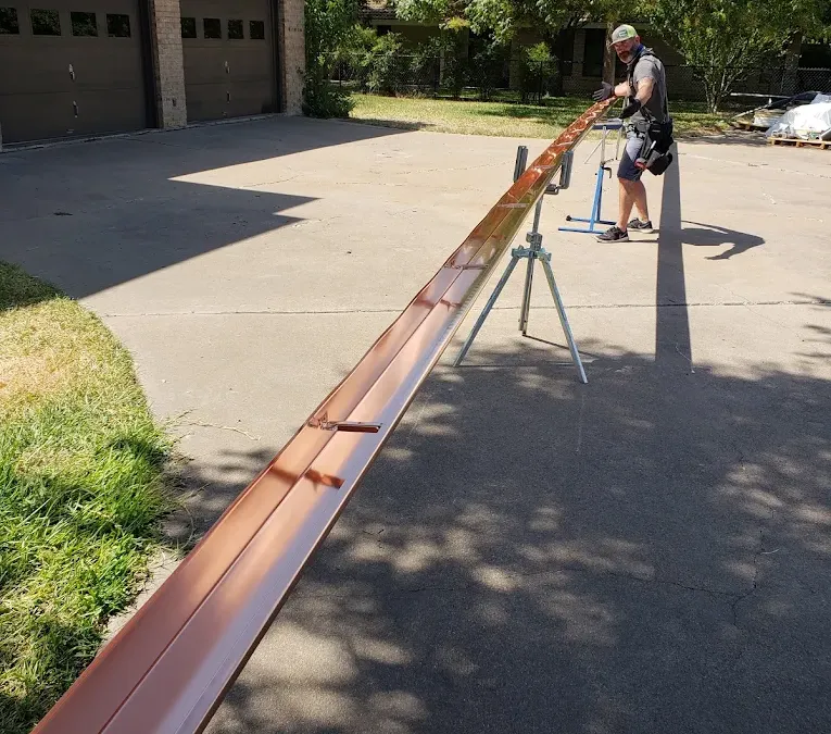 Tracy fabricating seamless gutters on-site with a gutter machine